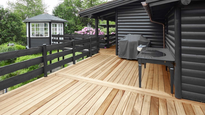 Træterrassen er i dette sommerhus med til at understrege både eksklusivitet og hygge i en smuk kombination med den omkringliggende natur. .